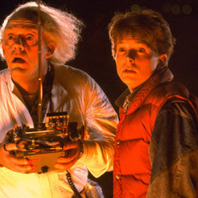 愛犬を乗せたデロリアンを操作する2人