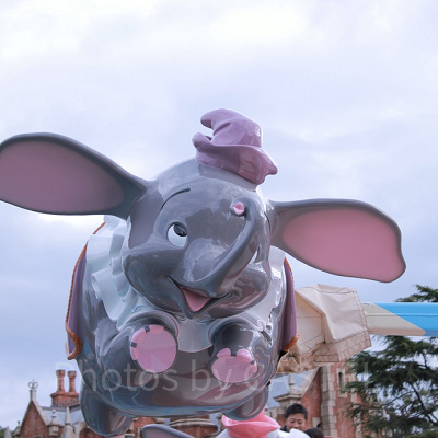カラフルな帽子と洋服をまとったダンボが空を舞います