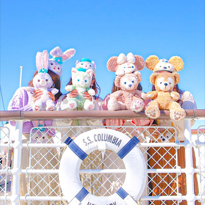 ダッフィーのぬいぐるみを持ってパークを楽しむ